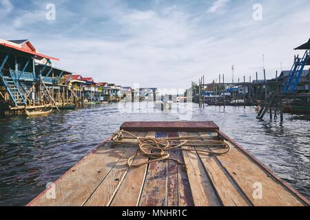 Barca in mezzo al villaggio galleggiante sul lago Tonle Sap. Siem Reap Provincia, in Cambogia. Foto Stock