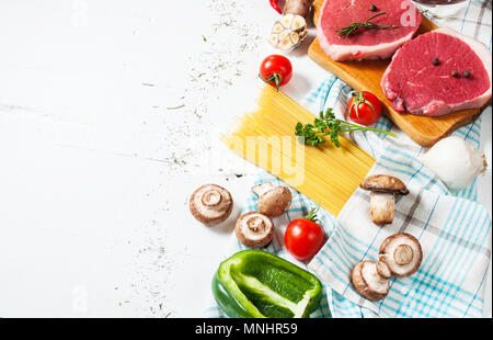 Materie carne di manzo con pasta, pomodori, funghi e formaggio bianco su sfondo tabella,copyspace. Foto Stock