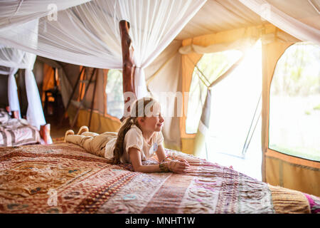 Bambina in tenda safari godendo di vacanza in Africa Foto Stock