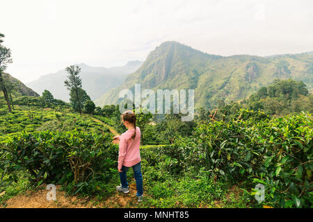 Bambina godendo di panorami mozzafiato sulle montagne e le piantagioni di tè in Ella lo Sri Lanka Foto Stock