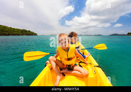 Kids godendo paddling in colorate in giallo kayak al Tropical Ocean acqua durante le vacanze estive Foto Stock