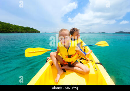 Kids godendo paddling in colorate in giallo kayak al Tropical Ocean acqua durante le vacanze estive Foto Stock