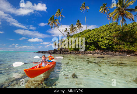 Kids godendo paddling in colorate di rosso il kayak al Tropical Ocean acqua durante le vacanze estive Foto Stock