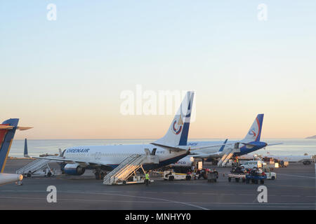 Code di alcuni aerei in aeroporto durante le operazioni di imbarco. Essi sono aerei sul tramonto. Viaggi e trasporti i concetti. Foto Stock