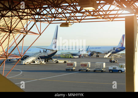 Code di alcuni aerei in aeroporto durante le operazioni di imbarco. Essi sono aerei sul tramonto. Viaggi e trasporti i concetti. Foto Stock