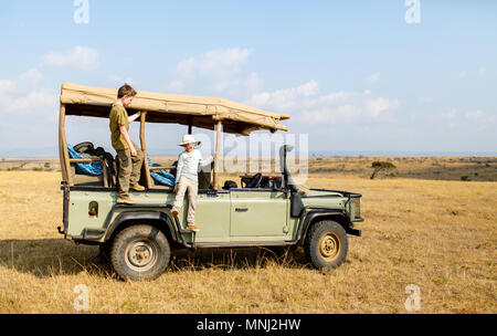 I bambini su game drive in veicolo aperto godendo di safari Foto Stock