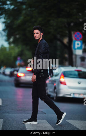 Ritratto di elegante uomo sulla notte sullo sfondo della città rappresentano per la fotocamera Foto Stock