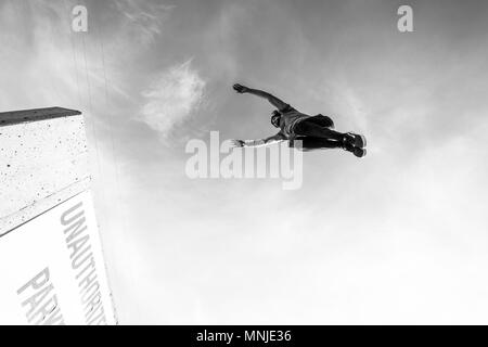 Atleta parco jumping alto gap nel parcheggio in centro a Denver, Colorado, STATI UNITI D'AMERICA Foto Stock