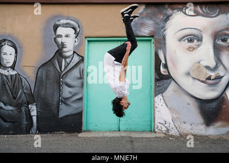 Montare giovane atleta di parkour facendo backflip davanti della street art, Santa Fe Arts District, Denver, Colorado, STATI UNITI D'AMERICA Foto Stock