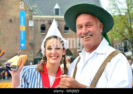 Coppia attraente la vendita di formaggi per la folla onlooking presso il mercato del formaggio di Alkmaar, Olanda, Netherlads Foto Stock