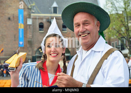 Coppia attraente la vendita di formaggi per la folla onlooking presso il mercato del formaggio di Alkmaar, Olanda, Netherlads Foto Stock