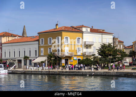 Parenzo in Istria, Croazia, Aprile 2018 - Una vista dal mare del lungomare pieno di passare i turisti e la gente del posto Foto Stock