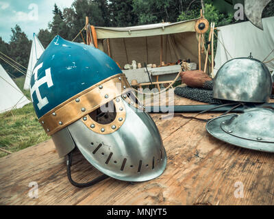 Scena medievale. Cavaliere medievale sono gli attributi casco, mail a catena, scudo buckler, spada, alabarda. La ricostruzione della vita medioevale Foto Stock