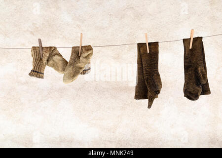 Due coppie di maglia calze di lana appeso a una fune di lavanderia con clothespins in legno Foto Stock