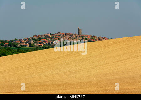 Villaggio di Montpeyroux e campo arato con l'orizzonte. Limonese. Puy de Dome. Auvergne. Francia Foto Stock