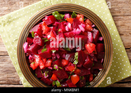 Insalata di barbabietole con cipolle, pomodori e le erbe aromatiche con olio di oliva close-up su una piastra. parte superiore orizzontale vista da sopra Foto Stock