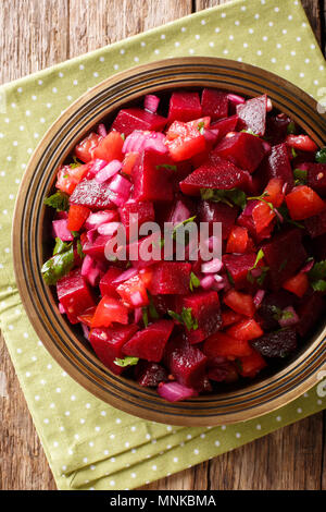 Insalata di barbabietole con cipolle, pomodori e le erbe aromatiche con olio di oliva close-up su una piastra. Verticale in alto vista da sopra Foto Stock