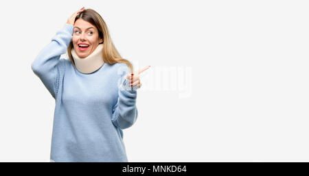 Giovani feriti donna che indossa il rinforzo del collo il collare rivolto lontano lato con un dito Foto Stock