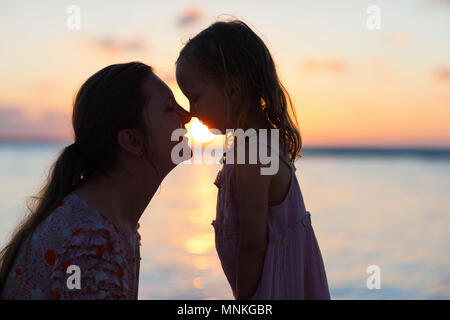 Sagome di madre e figlia al tramonto Foto Stock
