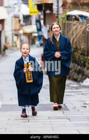 La famiglia di madre e figlia di indossare uno yukata tradizionale giapponese in kimono street di onsen resort città in Giappone. Foto Stock