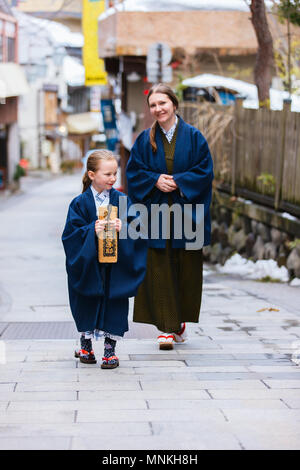 La famiglia di madre e figlia di indossare uno yukata tradizionale giapponese in kimono street di onsen resort città in Giappone. Foto Stock