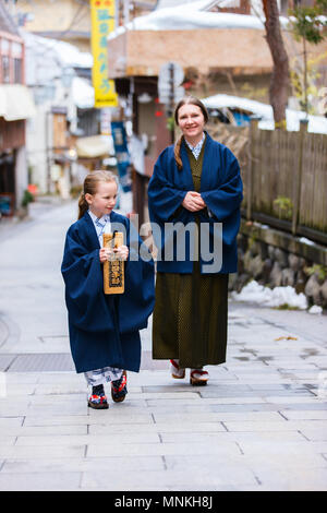 La famiglia di madre e figlia di indossare uno yukata tradizionale giapponese in kimono street di onsen resort città in Giappone. Foto Stock