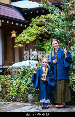 La famiglia di madre e figlia di indossare uno yukata tradizionale giapponese in kimono street di onsen resort città in Giappone. Foto Stock