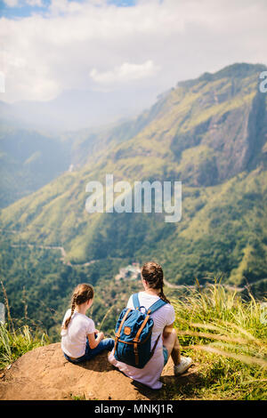 La famiglia della madre e del bambino che gode di viste mozzafiato sulle montagne e le piantagioni di tè da poco Adams picco in Ella lo Sri Lanka Foto Stock