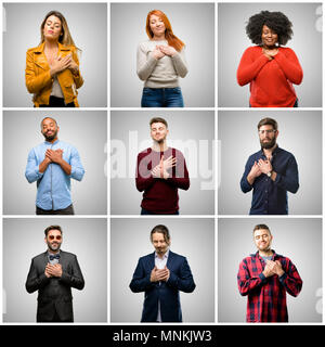 Gruppo di gente mista, le donne e gli uomini con le mani nel cuore, esprimere amore e il concetto di salute Foto Stock