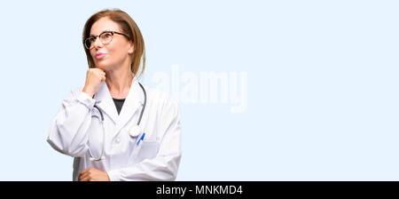 Medico donna, medico professionista il pensiero e la ricerca di esprimere dubbi e meraviglia isolato sfondo blu Foto Stock