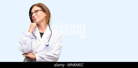 Medico donna, medico professionista il pensiero e la ricerca di esprimere dubbi e meraviglia isolato sfondo blu Foto Stock