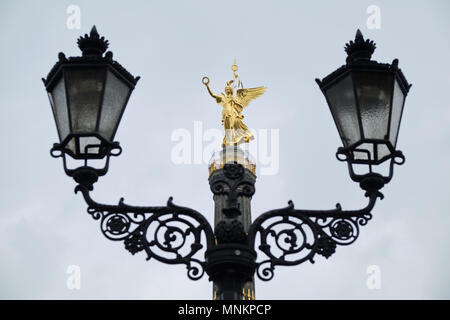 Berlino, Germania - 14 Aprile 2018: la statua di Victoria sulla parte superiore della colonna della vittoria in Tiergarten con lampade lanterna in primo piano Foto Stock