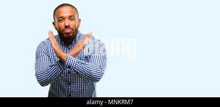 African American uomo con barba infastiditi con cattivo atteggiamento facendo segno di stop attraversando le mani, dicendo no, esprimendo la sicurezza, la difesa o la restrizione isol Foto Stock