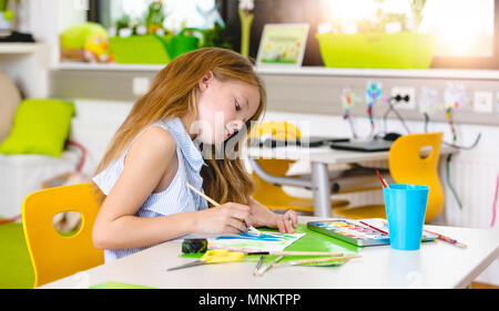 A scuola - abbastanza schoolgirl è il disegno in lezioni di pittura Foto Stock