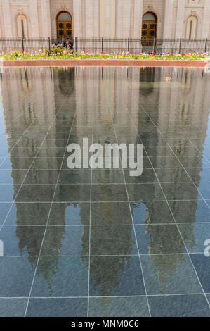 Un anatra nuota in un stagno riflettente sotto le torri di Salt Lake tempio mentre inizio estate matrimoni sono celebrati. Chiesa di Gesù Cristo LDS. Foto Stock