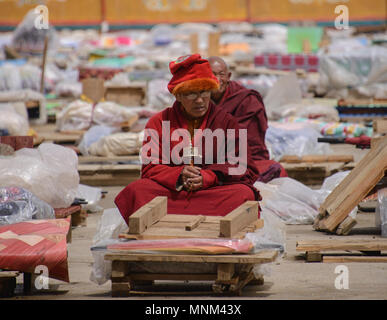 Monaco tibetano sulla sua piattaforma di meditazione, Yarchen Gar, Sichuan, in Cina Foto Stock