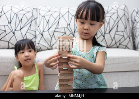 Cinese asiatici piccole sorelle giocando cataste di legno a casa Foto Stock