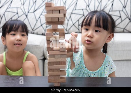 Cinese asiatici piccole sorelle giocando cataste di legno a casa Foto Stock