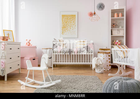 Baby room in stile scandinavo con il cavallo a dondolo, bianco cot Foto Stock