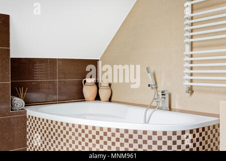 Un lussuoso bagno interno in marrone con piastrelle a mosaico vasca da bagno Foto Stock