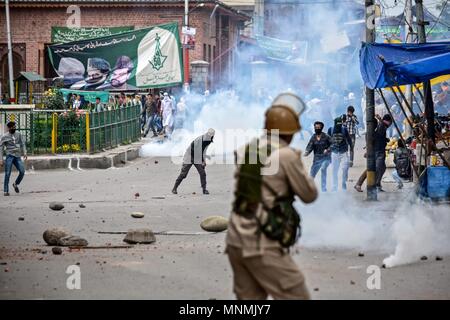 Kashmir Srinagar. Il 18 maggio 2018. Manifestanti del Kashmir scagliare pietre in mezzo a strappare il fumo durante gli scontri con il governo indiano le forze in Srinagar, Indiano Kashmir amministrato. Un gran numero di manifestanti ha preso parte in un rally a Srinagar, la più grande città del contestato valle himalayana, dopo la preghiera del venerdì, e chiedeva la fine dell'occupazione israeliana delle terre palestinesi. Credito: SOPA Immagini limitata/Alamy Live News Foto Stock