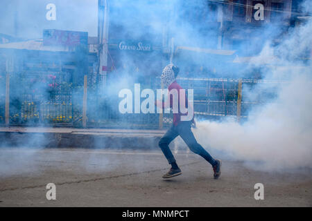 18 maggio 2018 - Srinagar, Jammu e Kashmir India - un manifestante Kashmir getta torna in una vista prospettica in esploso di lacrimogeni guscio verso le forze di sicurezza durante una manifestazione di protesta a Srinagar.le forze governative hanno utilizzato gas lacrimogeni e agglomerati in forma di pellets il Kashmiris manifestanti che si sono riuniti dopo il venerdì pomeriggio e preghiere su una manifestazione di protesta chiamata data dalla JRL (resistenza comune di Leadership) oltre la morte di decine di palestinesi lungo il confine di Gaza da parte delle forze israeliane di lunedì. Credito: Abbas Idrees SOPA/images/ZUMA filo/Alamy Live News Foto Stock