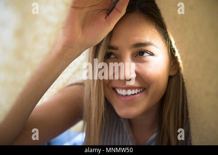 Sorridente giovane donna sotto coperta Foto Stock