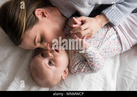 Madre kissing Baby girl (18-23 mesi) con cura Foto Stock