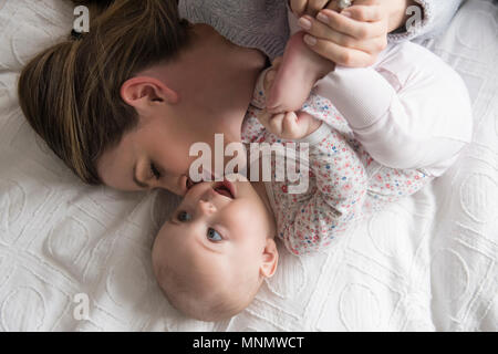 Madre kissing Baby girl (18-23 mesi) con cura Foto Stock