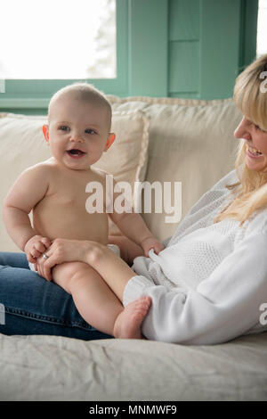 Madre seduta con il bambino (12-17 mesi) sul lettino Foto Stock