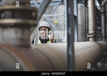 Femmina lavoratore industriale utilizzando la radio sul sito Foto Stock