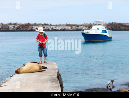 Femmina leone di mare rilassante vicino a un ragazzo a costa del sud Plaza isola Galapagos Foto Stock