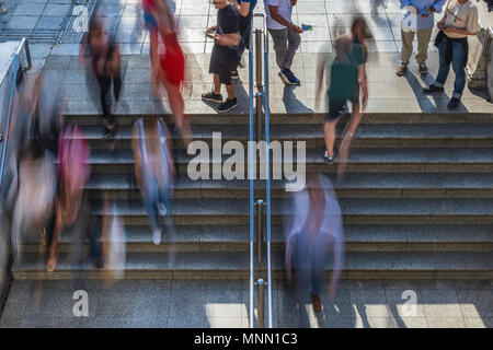 Overhead offuscata la gente camminare su e giù per le fasi di ingresso e di uscita della metro Foto Stock