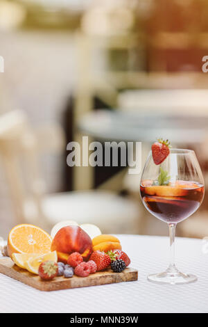 Tradizionale bevanda estiva sangria - rosso, rosa e bianco. Con champagne, rosa e vino rosso, fragole, arance, limone, mela verde e pompelmo. copia spazio per il testo. Foto Stock